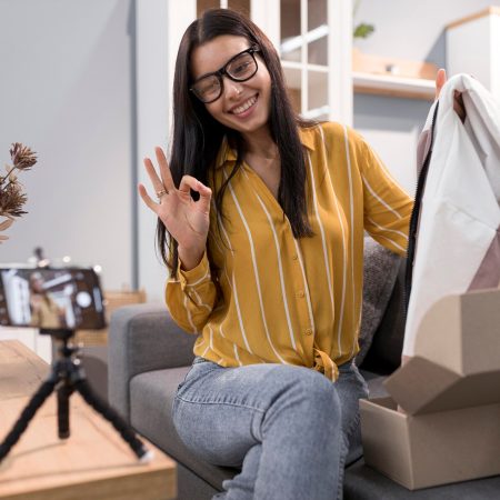 vlogger-home-unboxing-clothes-with-smartphone_23-2148738211